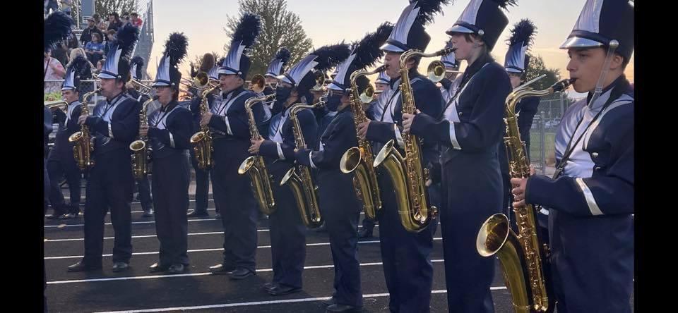 SHS marching band sax players line up while wearing new uniforms.
